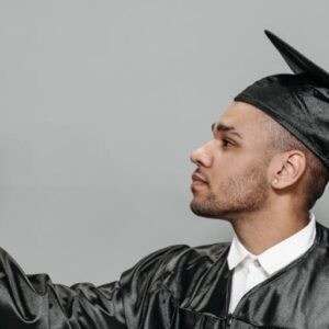 photo of man in black academic gown holding basketball
