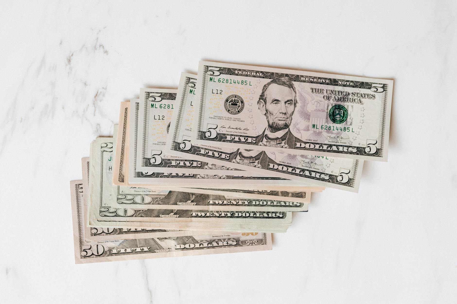stack of dollar bills on marble surface